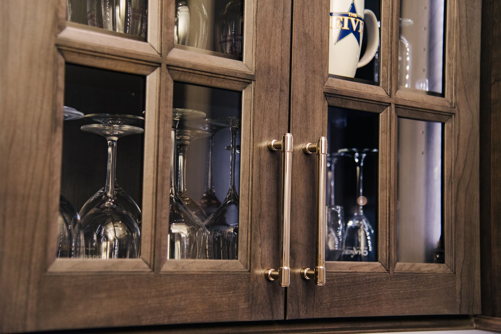A cup with a star on it sits in a glass cabinet