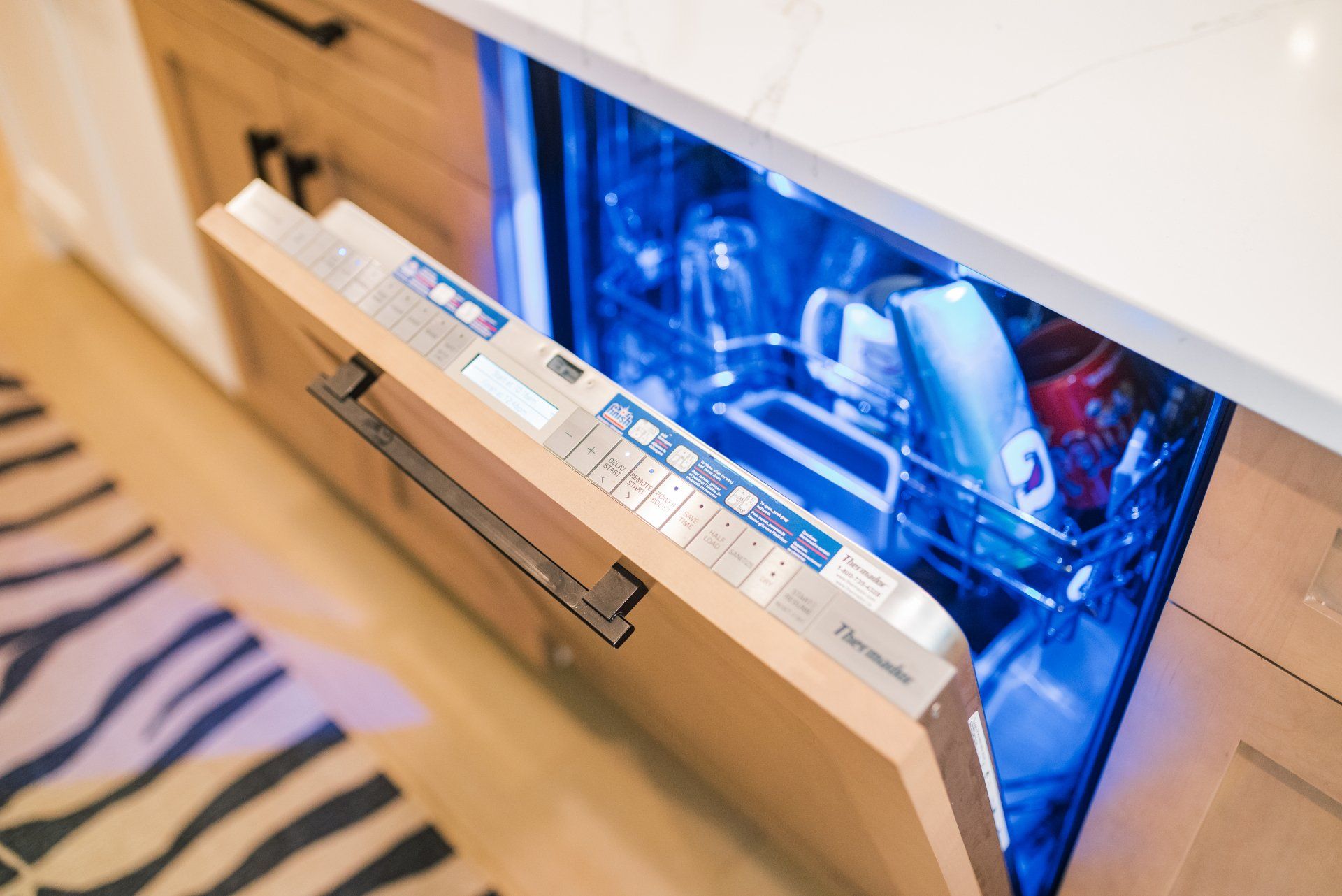 A close up of a dishwasher with the door open in a kitchen.