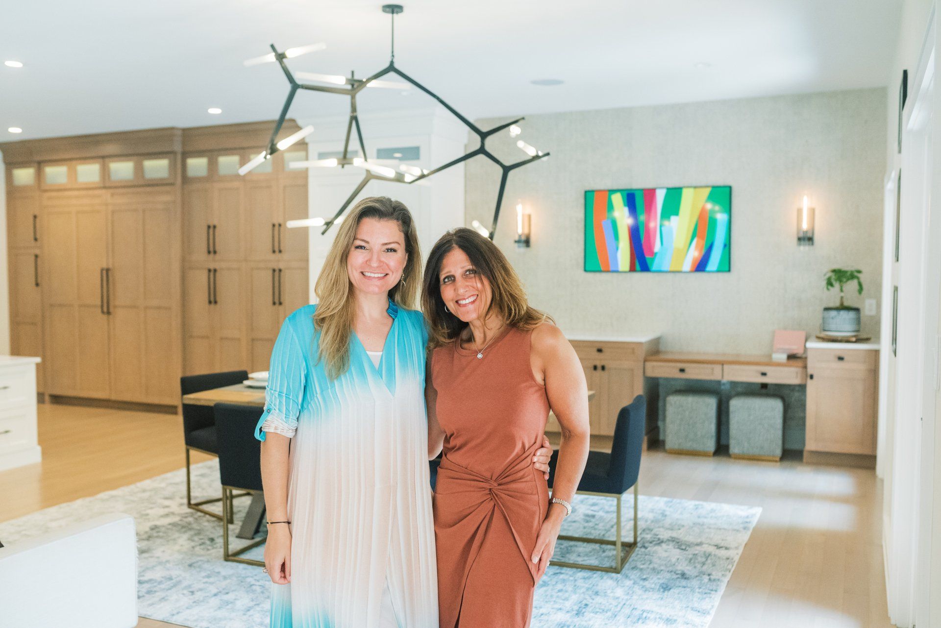 Two women are standing next to each other in a living room.