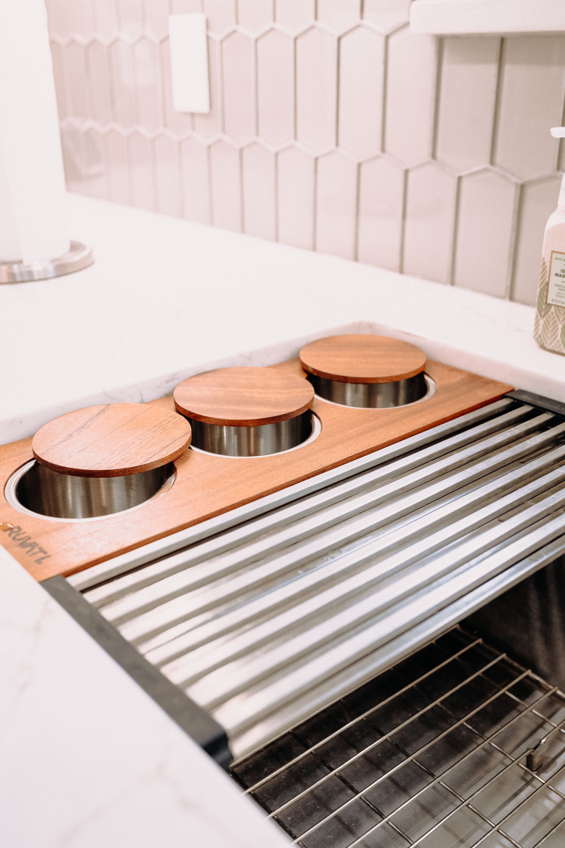 A kitchen sink with a wooden tray on top of it