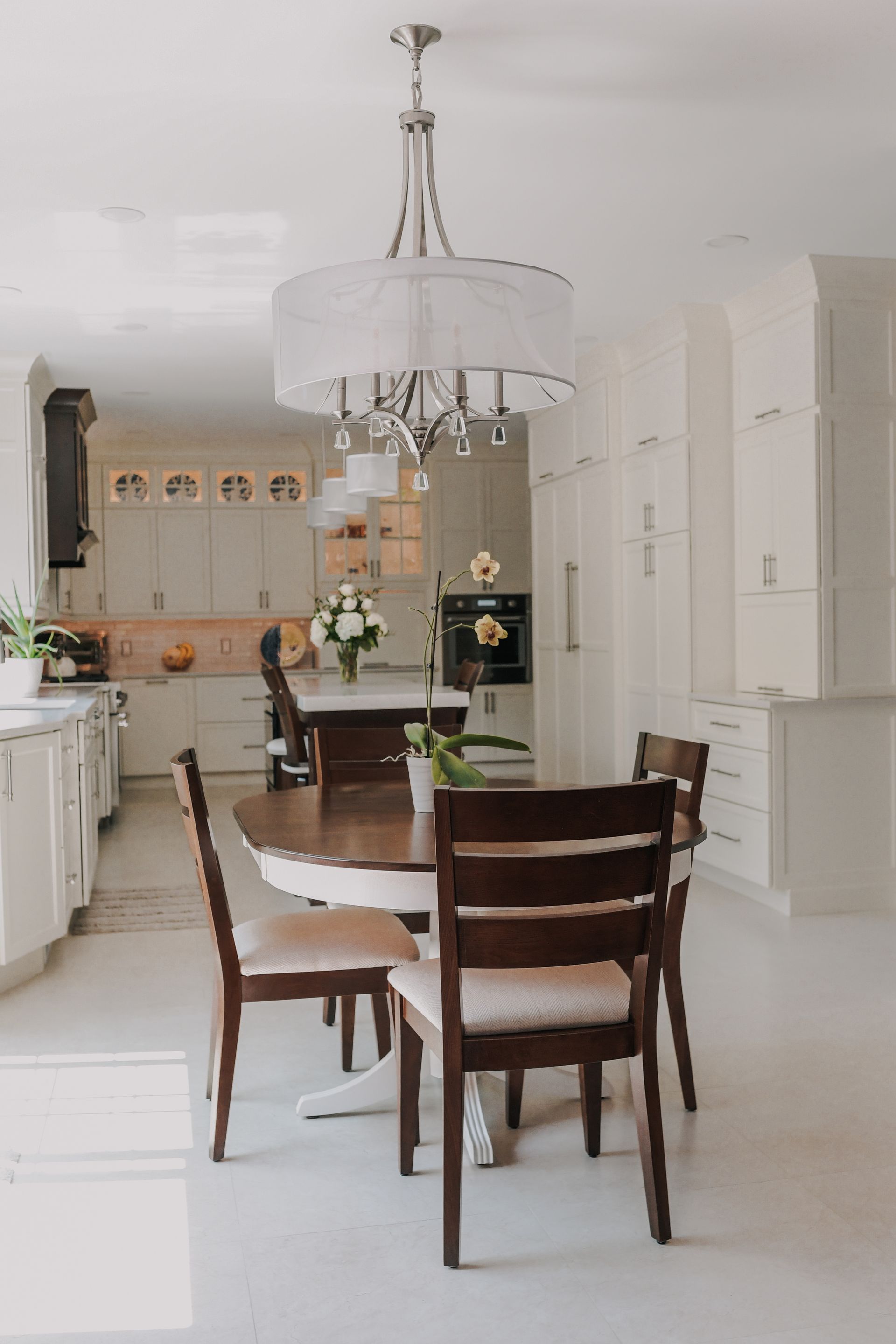 A kitchen with a table and chairs and a chandelier.