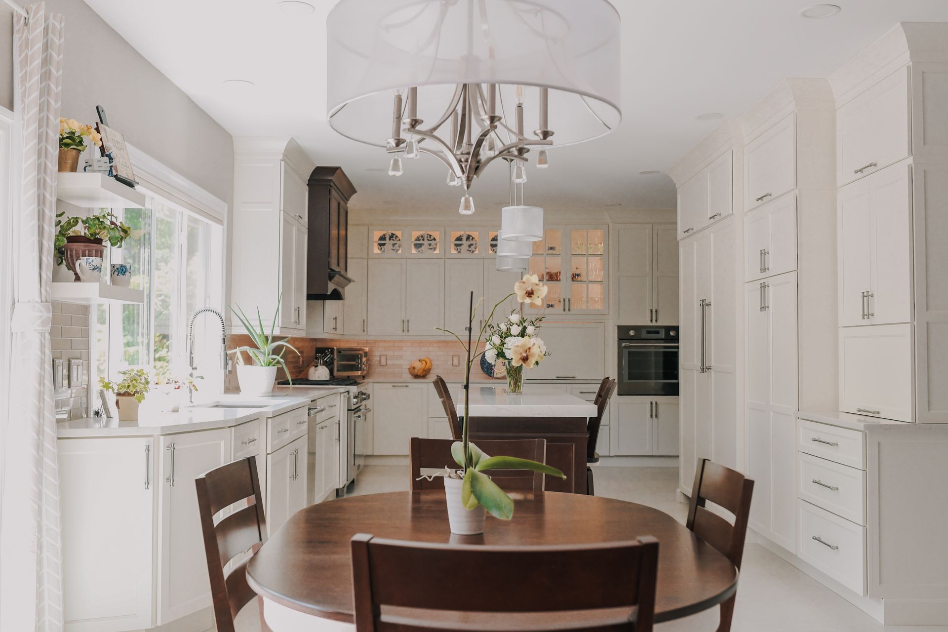 A kitchen with a round table and chairs and a chandelier.