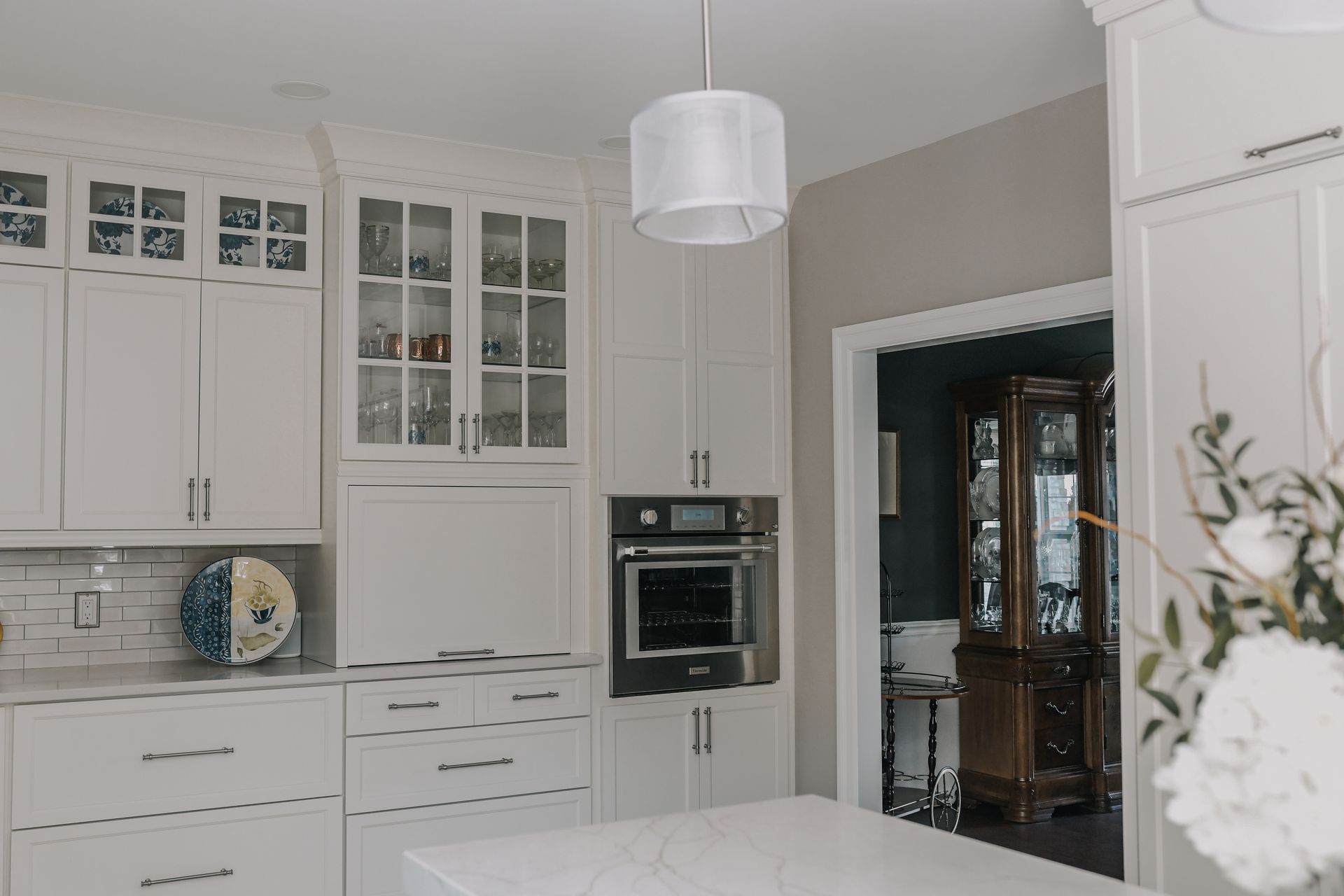 A kitchen with white cabinets and a white counter top.