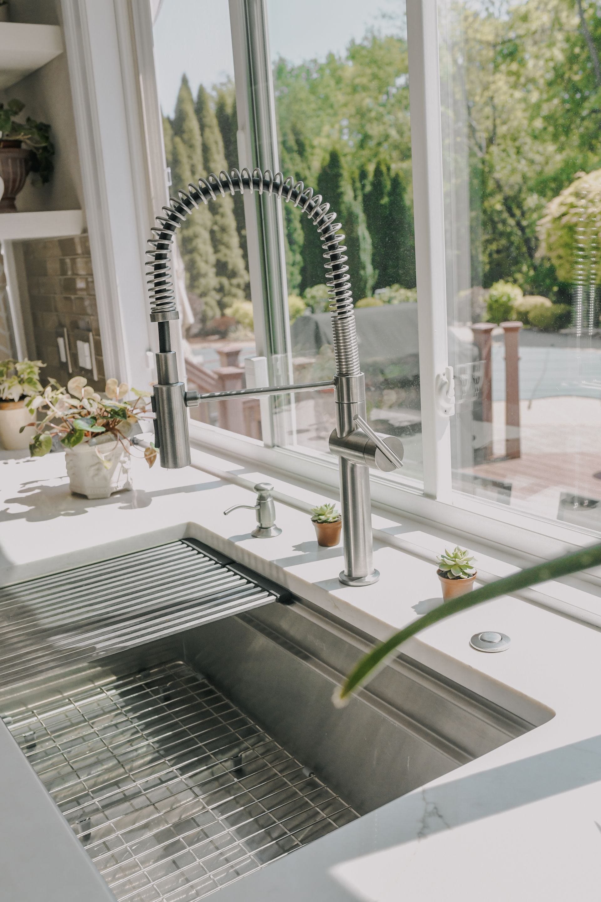 A kitchen sink with a faucet and a window.
