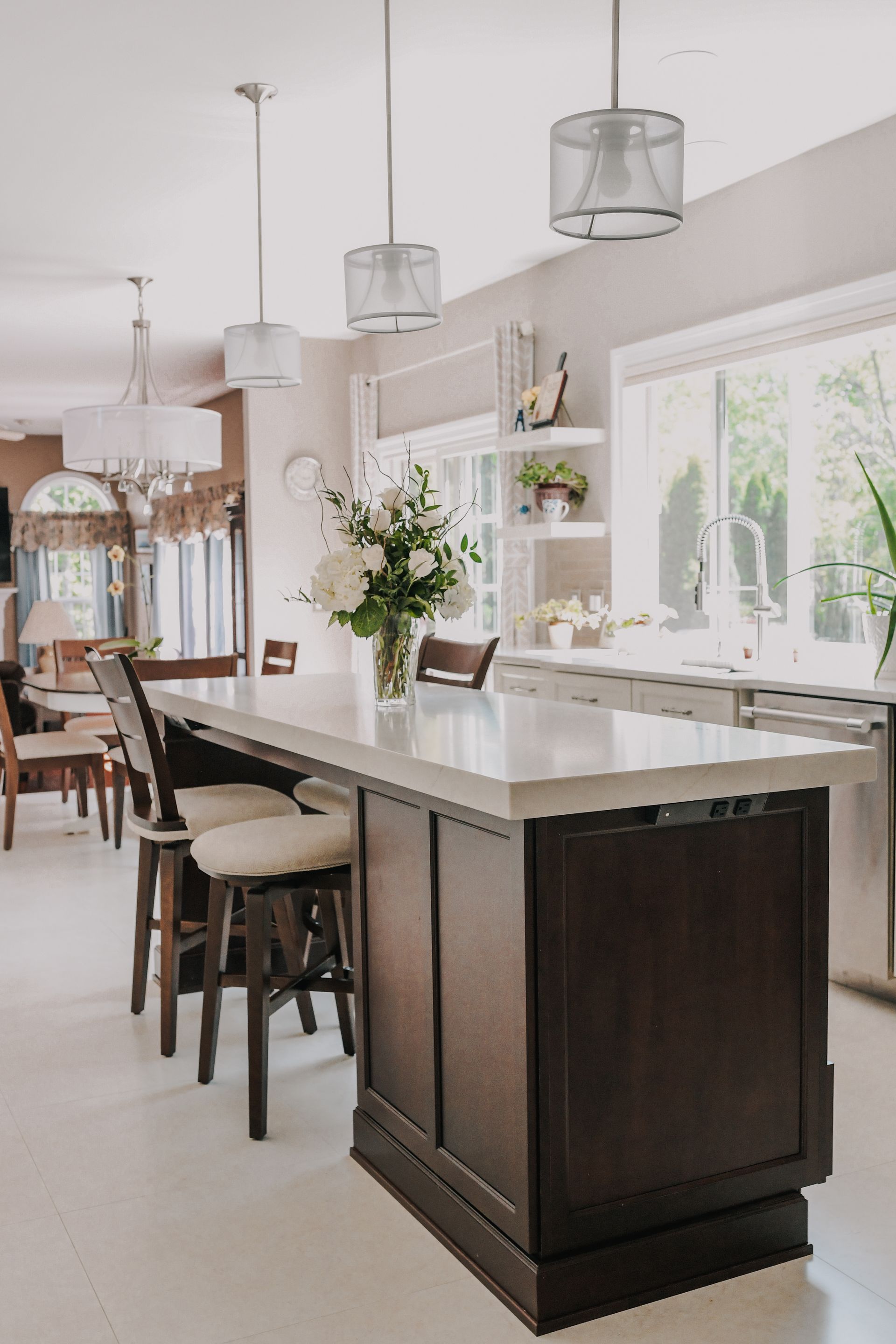 A kitchen with a large island and a vase of flowers on the counter.