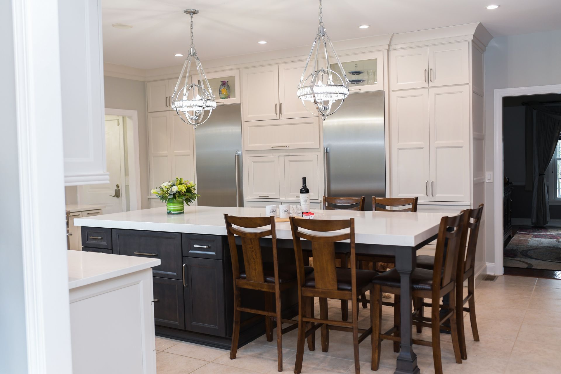 A kitchen with a table and chairs and stainless steel appliances.