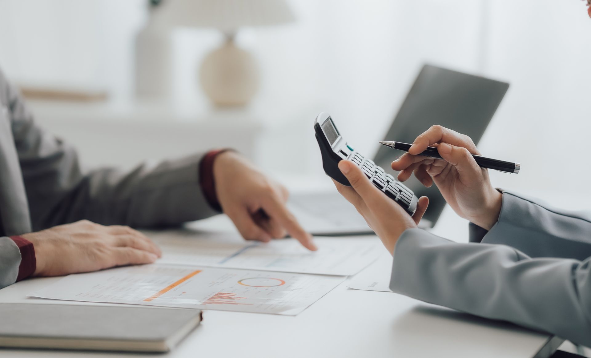 A Man and a Woman Are Sitting at a Table Using a Calculator