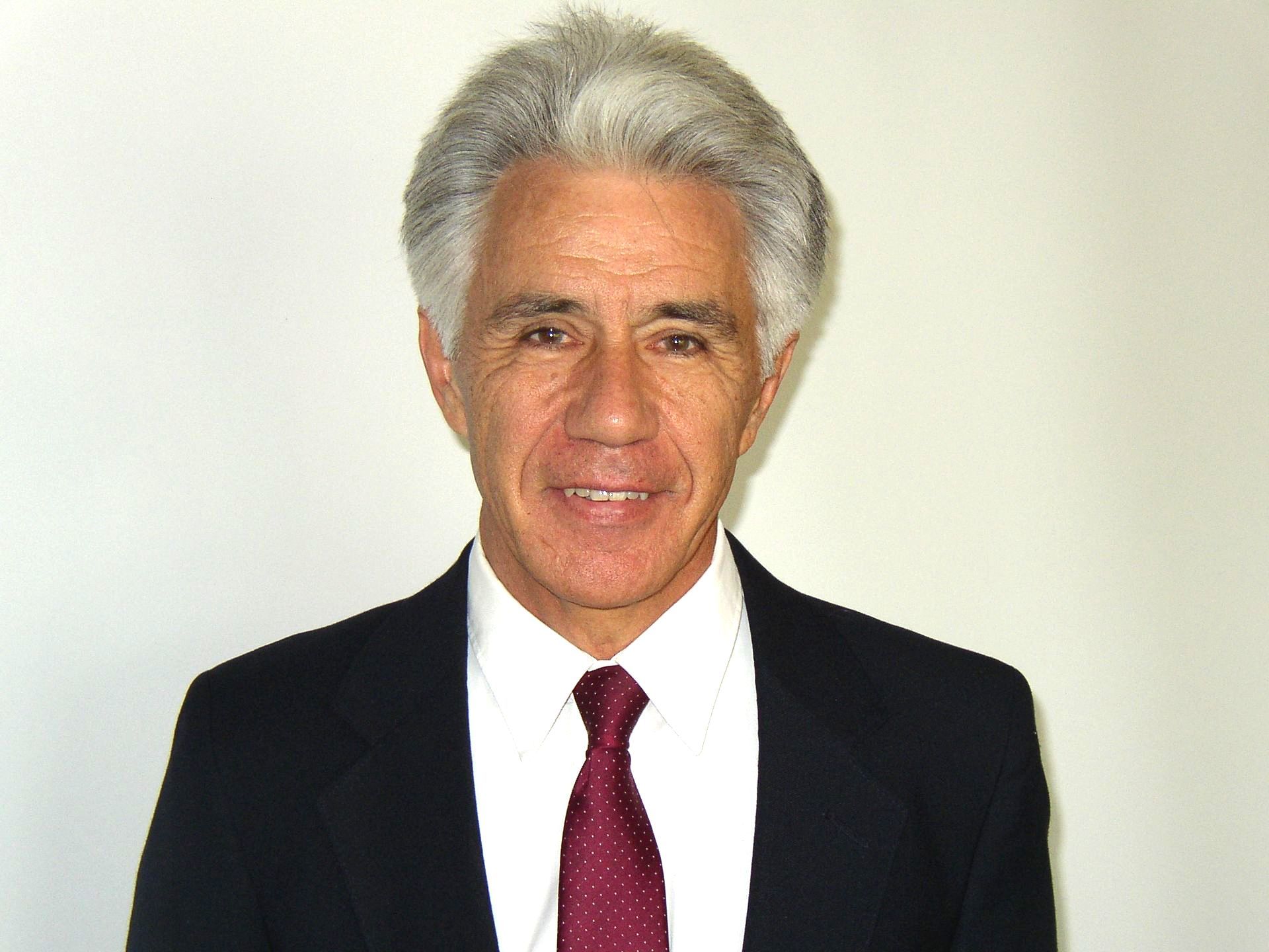 a man wearing glasses and a blue shirt is smiling for the camera