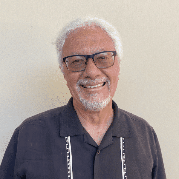 a man wearing glasses and a blue shirt is smiling for the camera