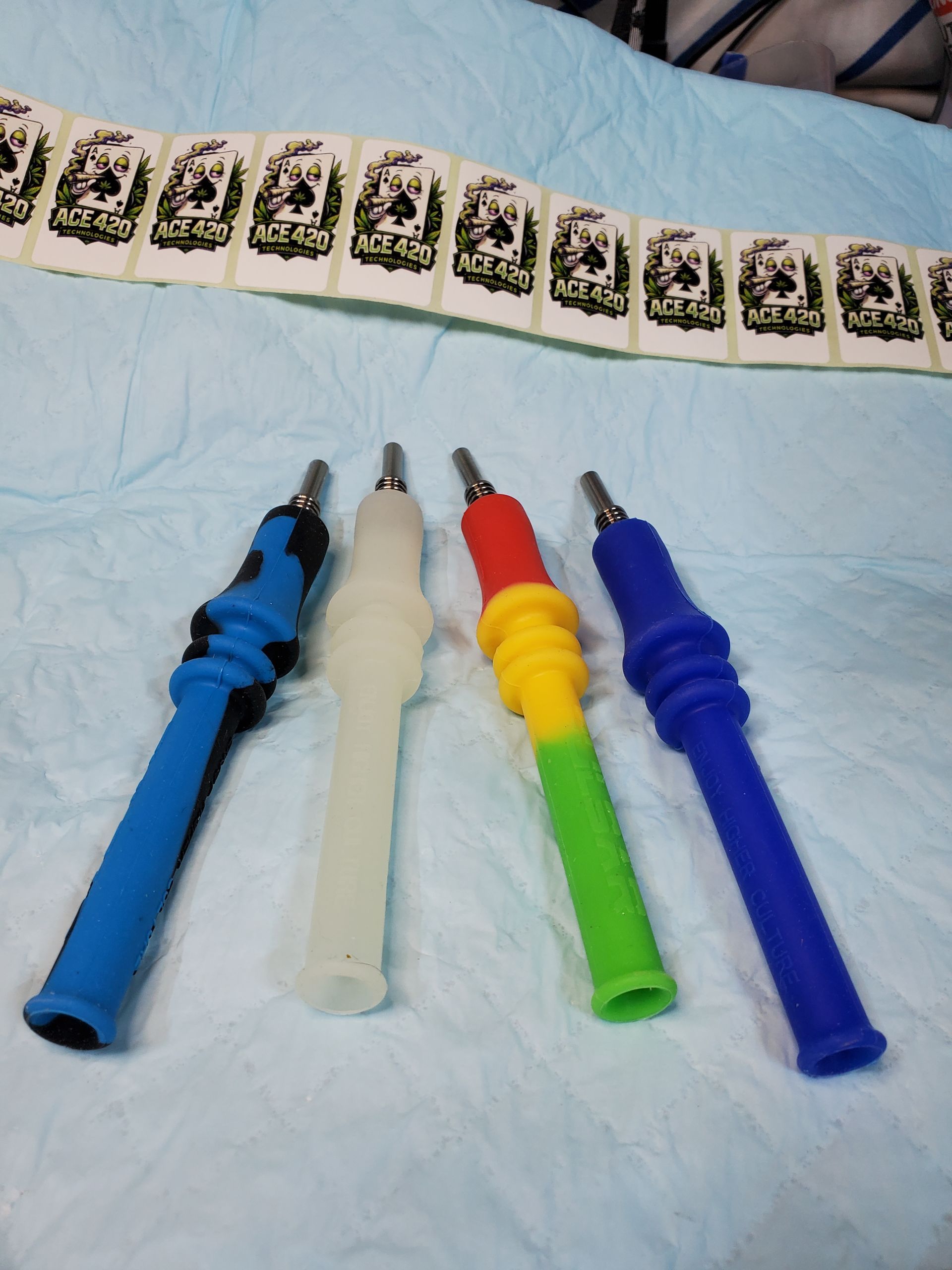 Scattered colorful pens and markers on a white bed or blanket with small snack packets nearby