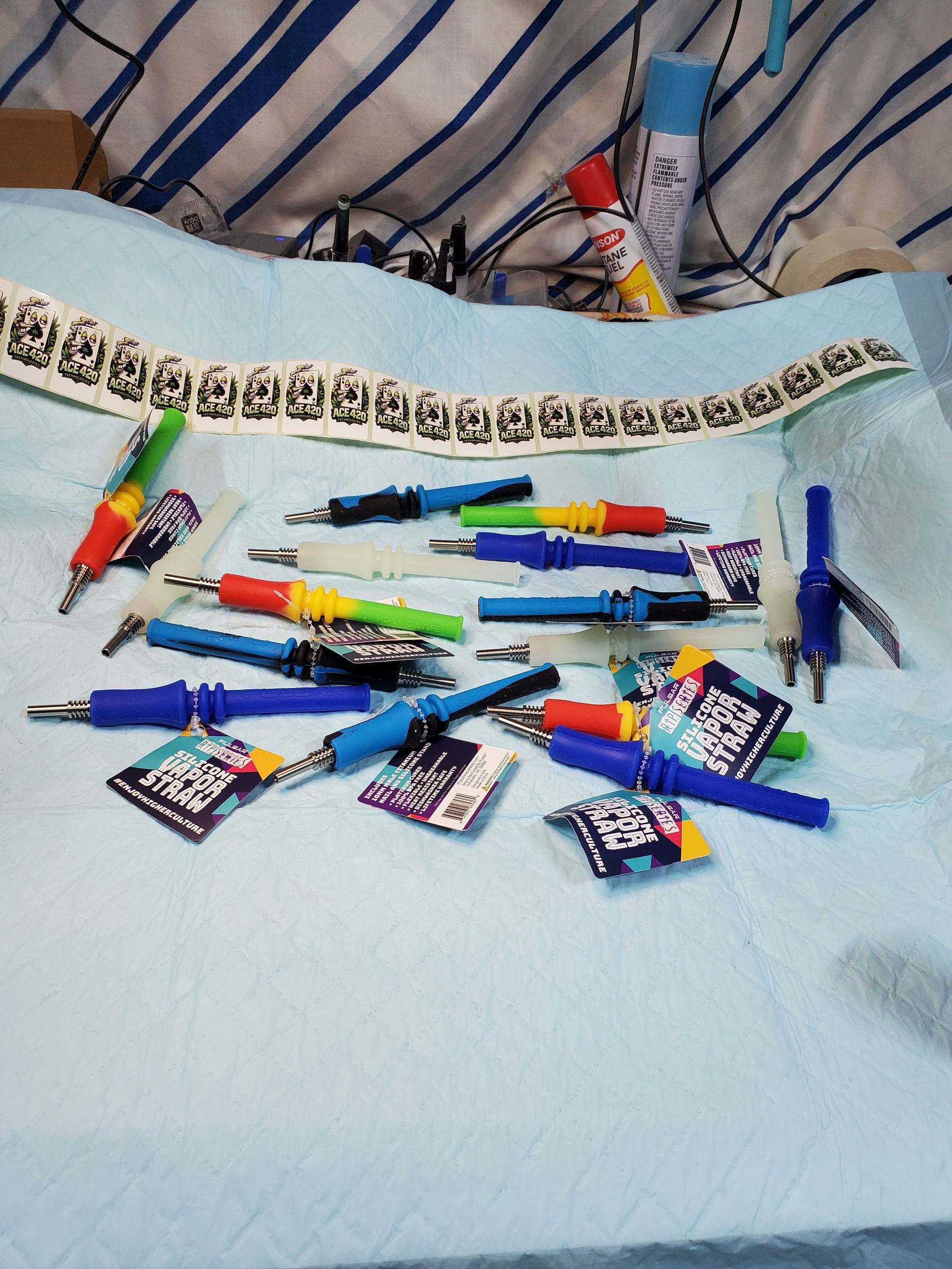 Scattered colorful pens and markers on a white bed or blanket with small snack packets nearby
