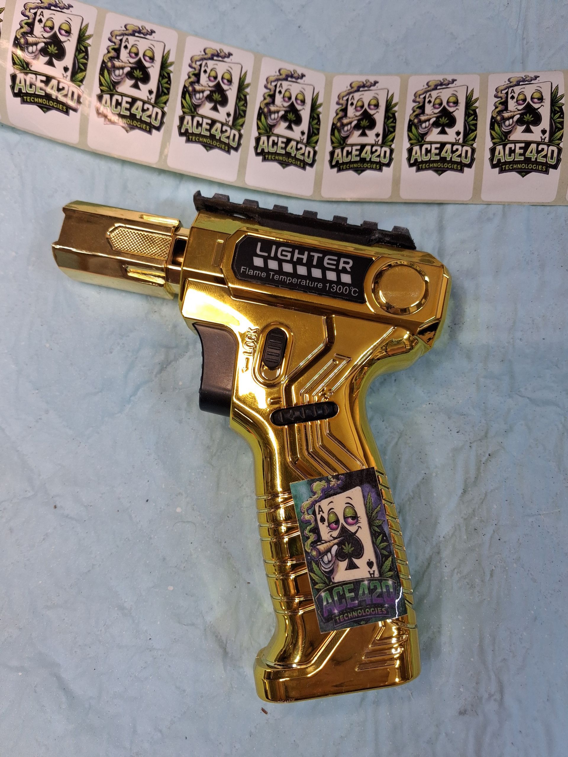 Gold lighter shaped like a pistol, with a leopard-print strip in the background