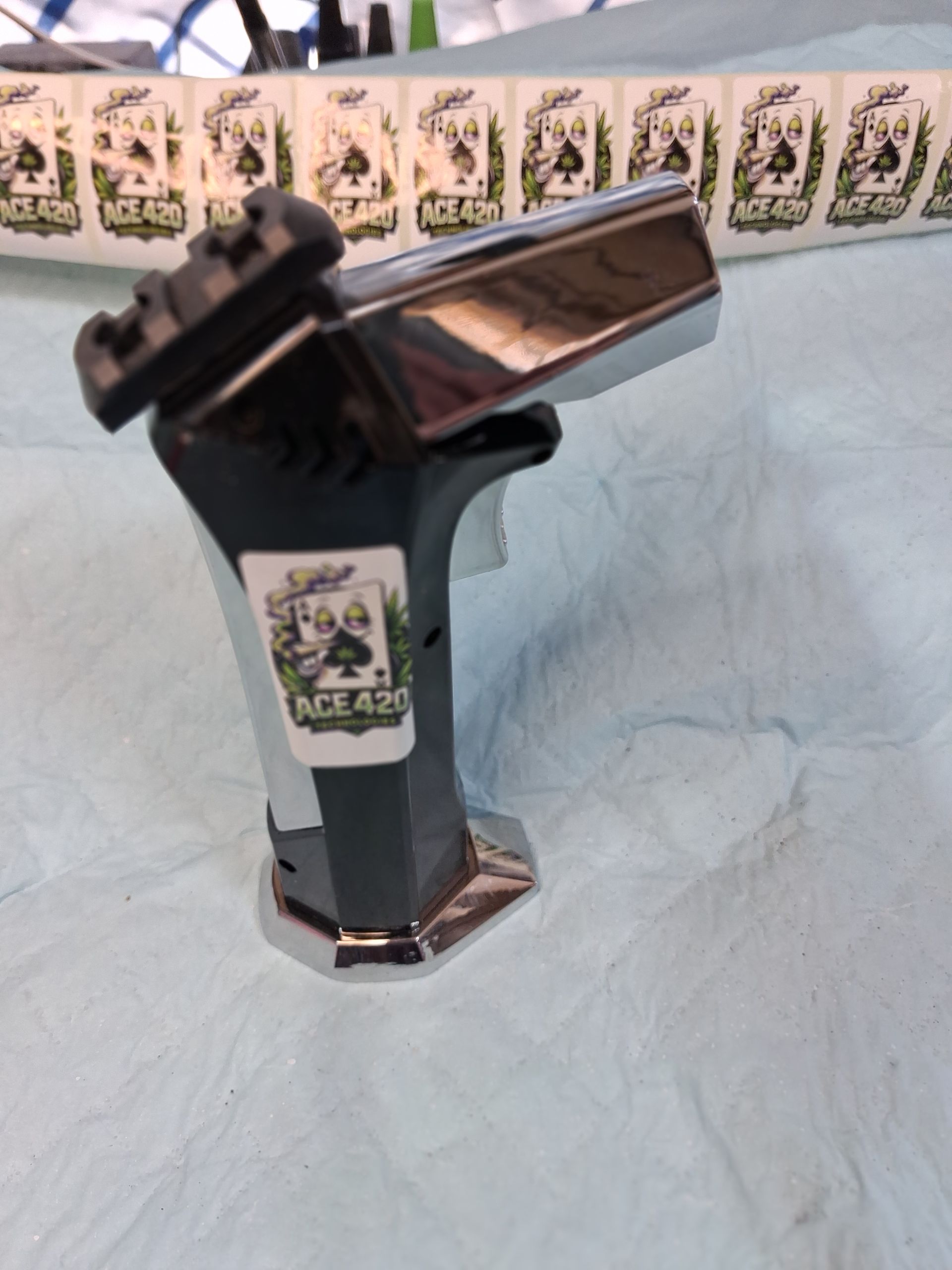 Two lighters, one black and one silver, standing upright on a light blue surface.