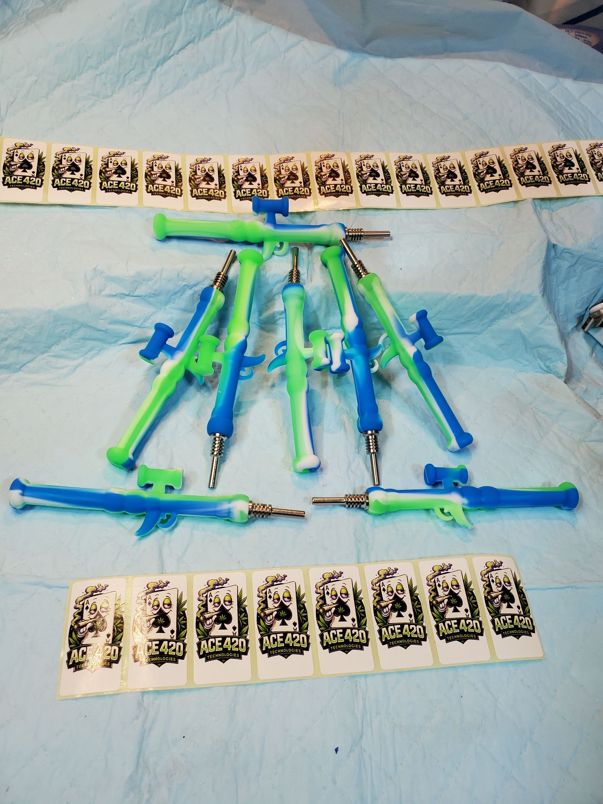 Assorted colorful toy swords and knives arranged on a bed with patterned cards above and below