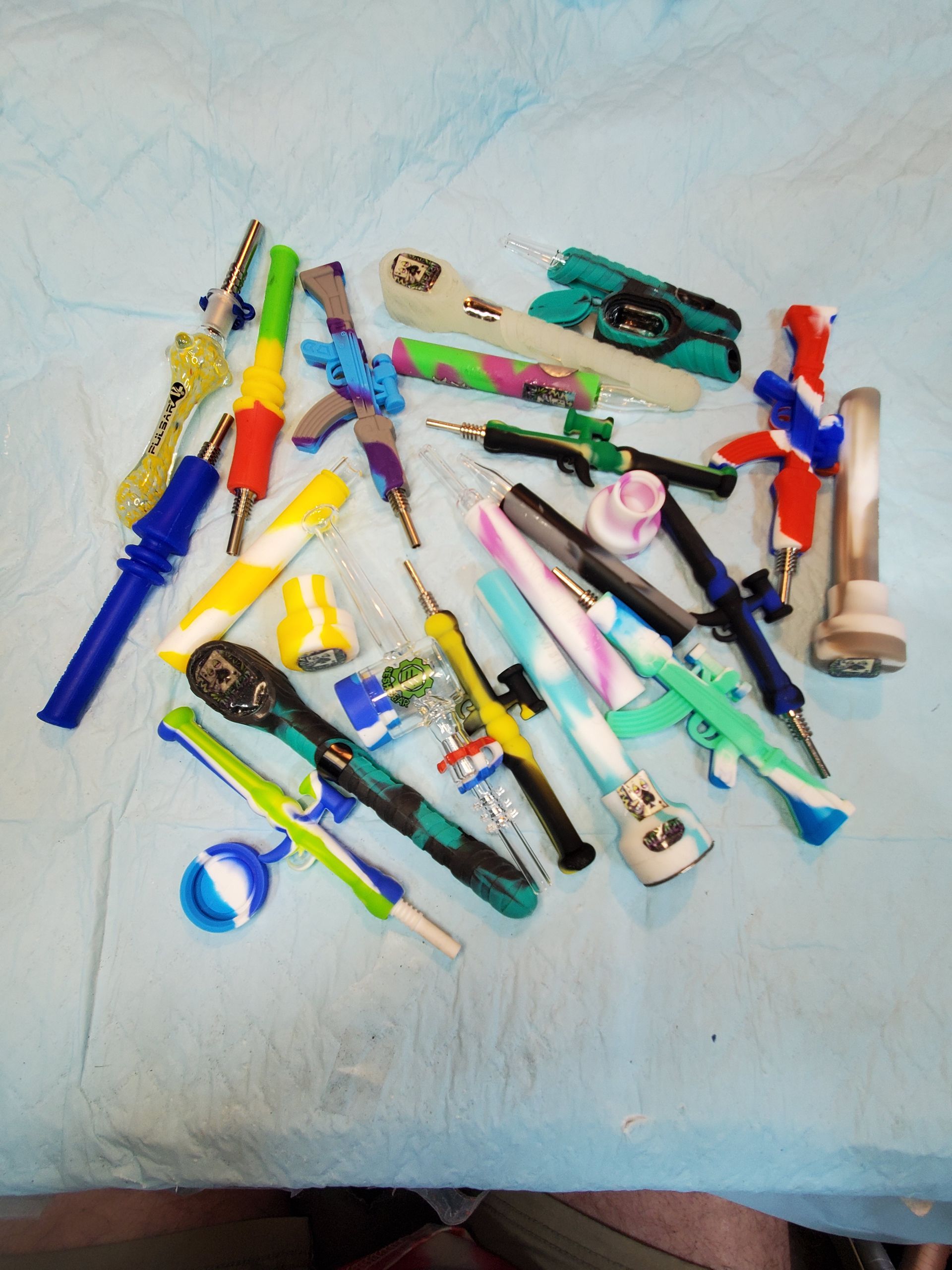 Assorted colorful toy tools and pens scattered on a light tabletop.