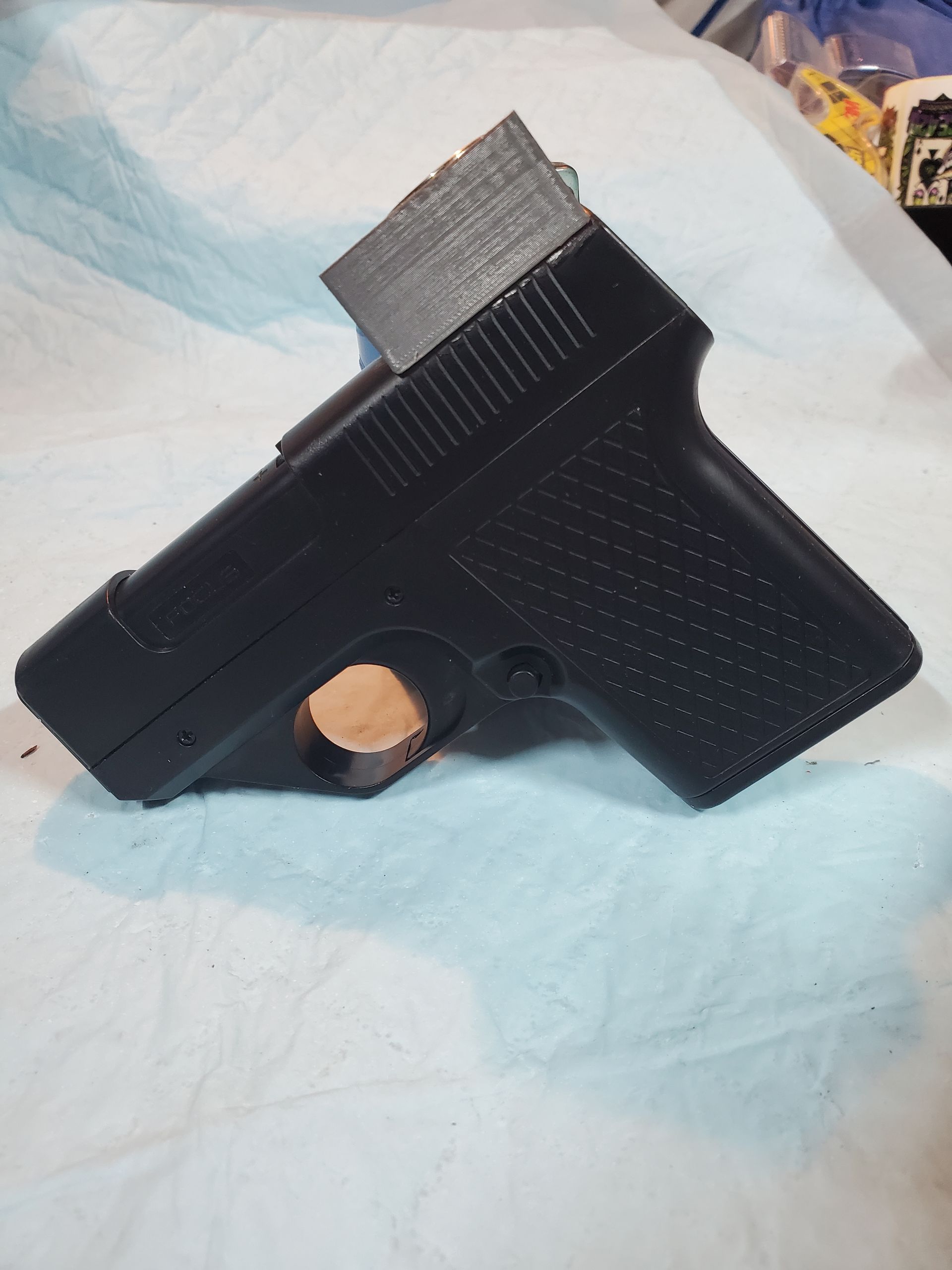 Brown handgun with two magazines on a light cloth background