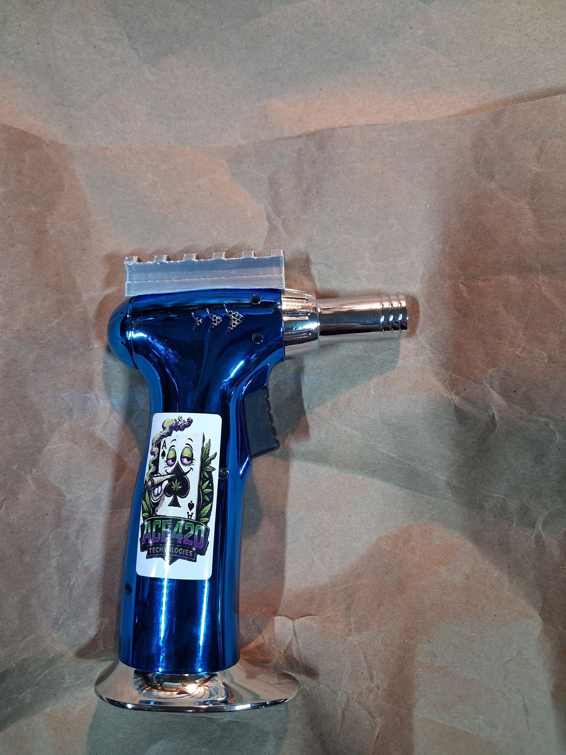 Blue handheld butane torch lighter on brown paper background