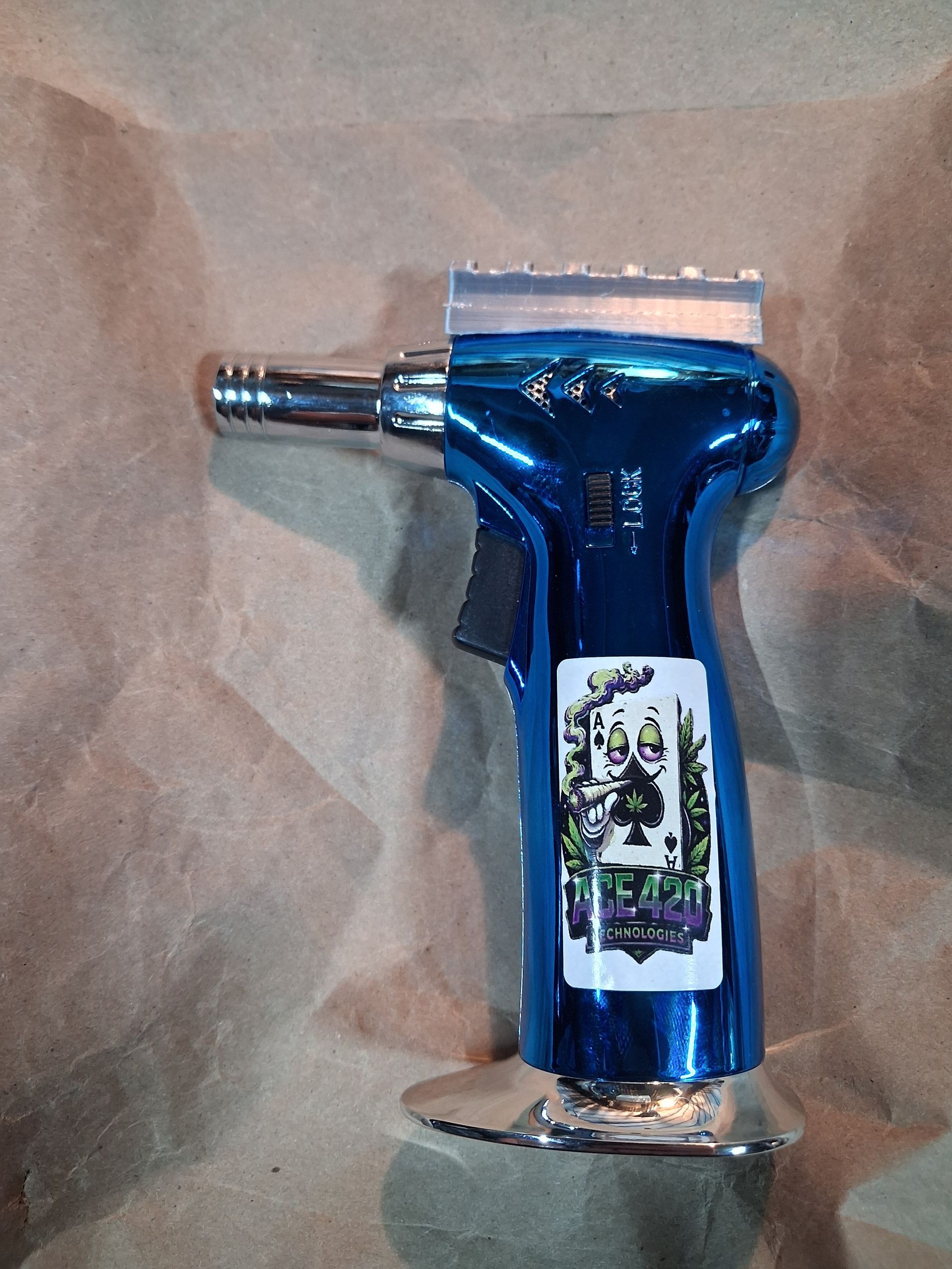 Blue handheld butane torch lighter on brown paper background