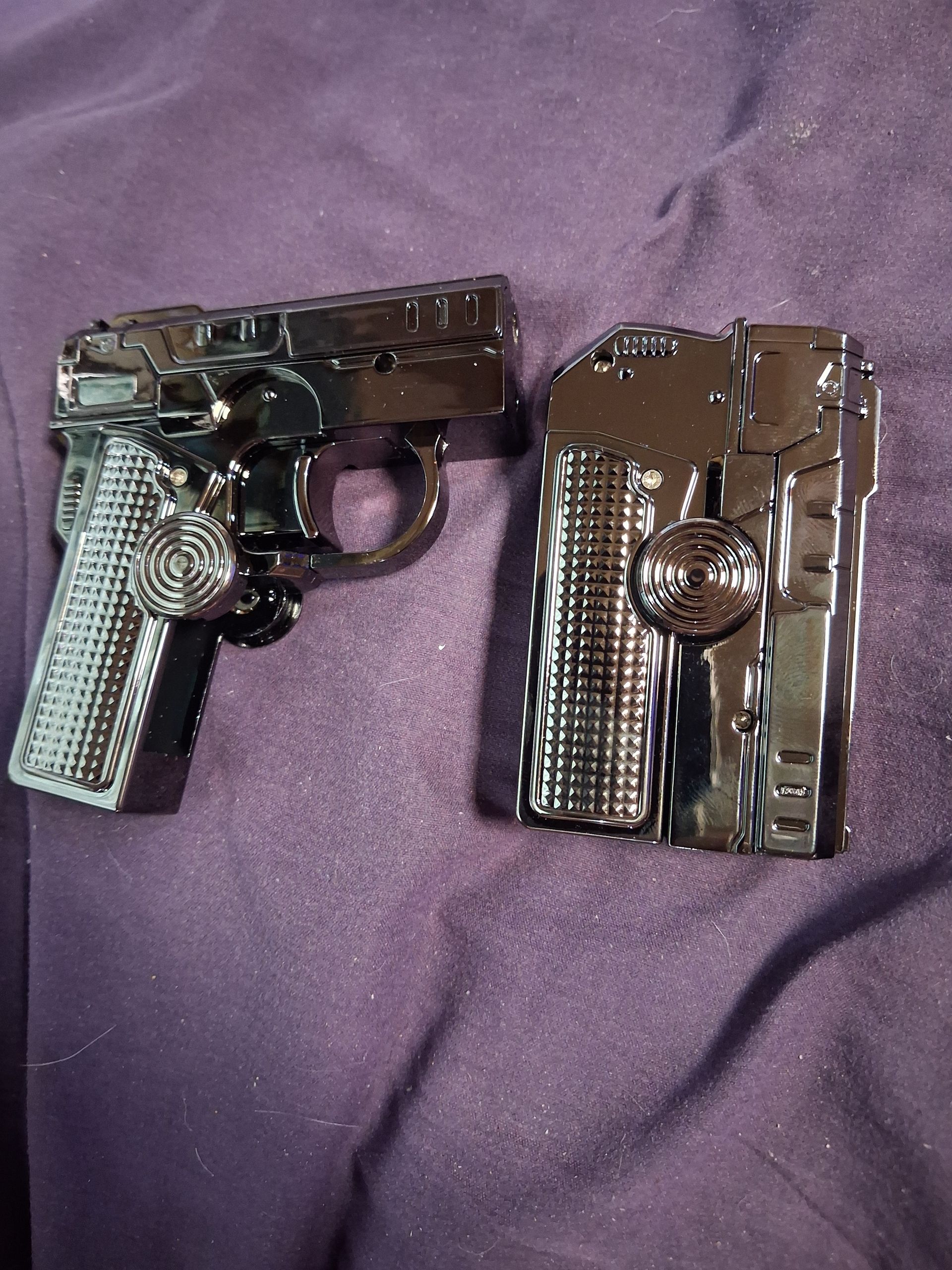 A black handgun and a black holster on a purple fabric surface.