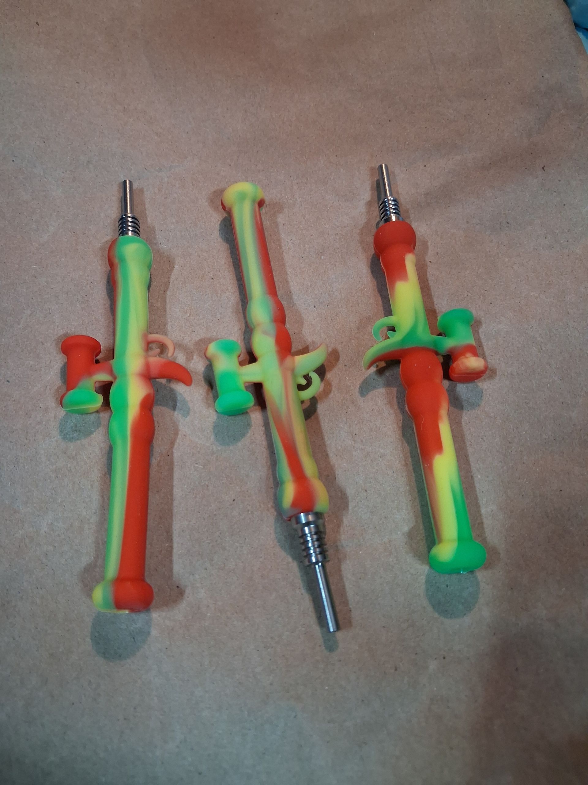 Assorted colorful toy swords and knives arranged on a bed with patterned cards above and below