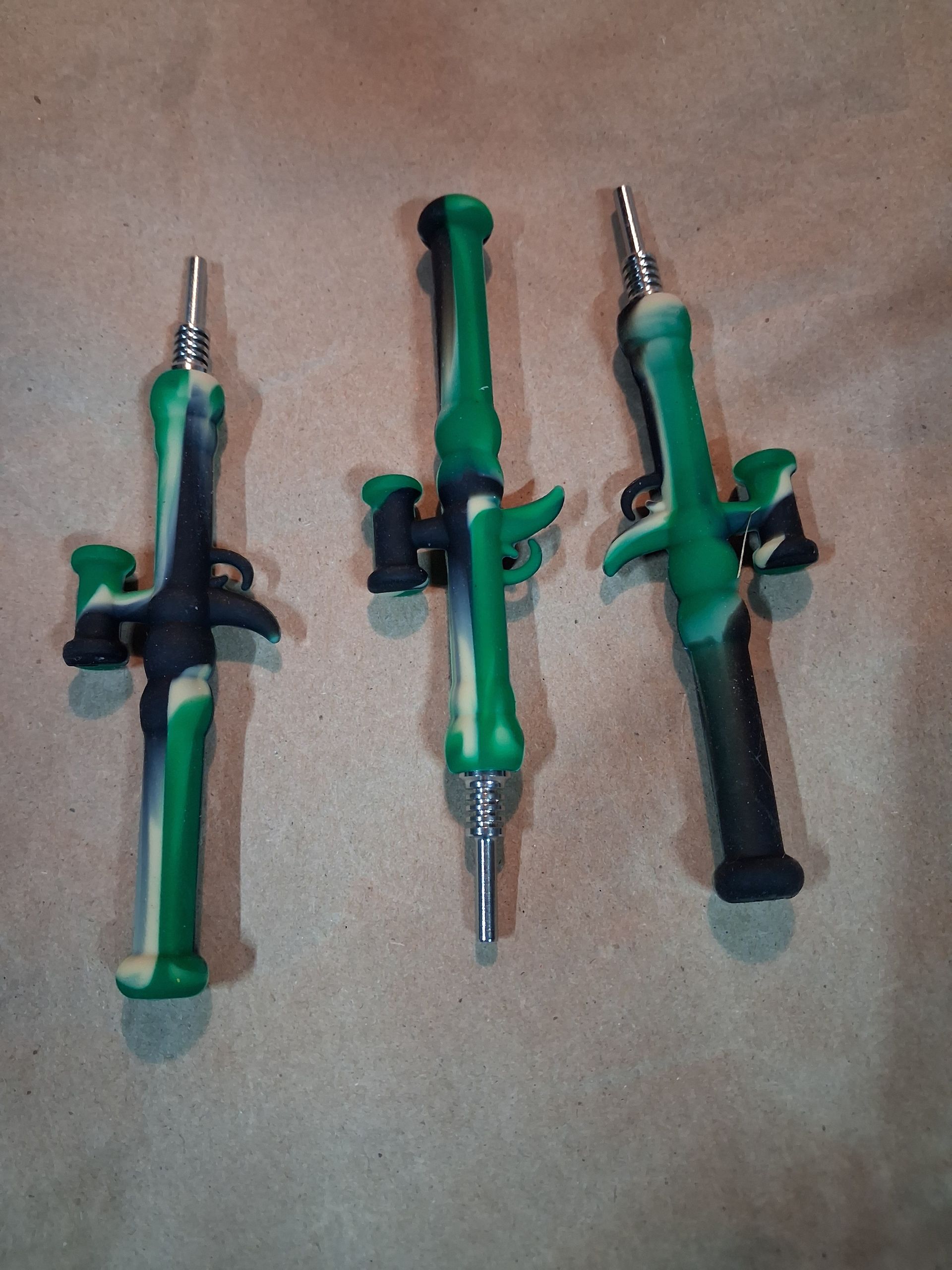 Assorted colorful toy swords and knives arranged on a bed with patterned cards above and below