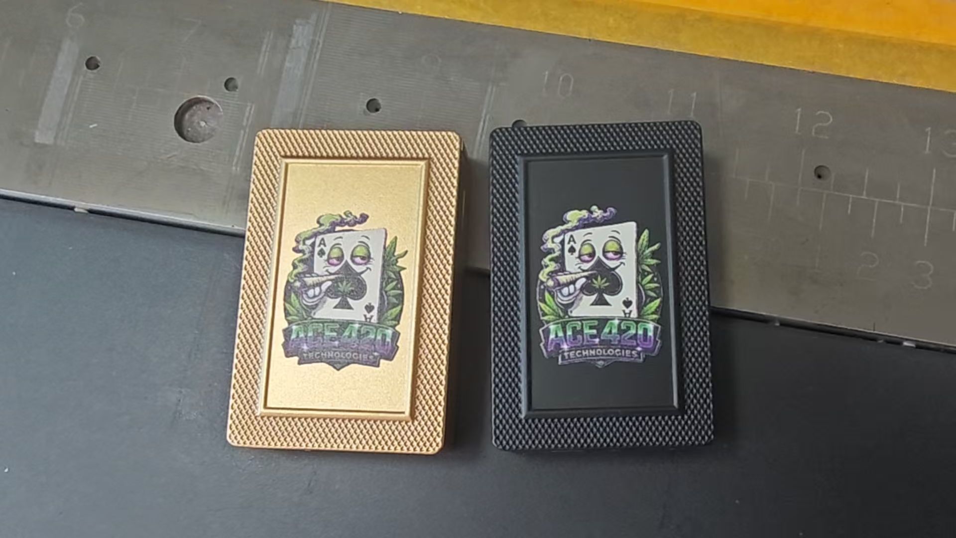 Two decorated rectangular boxes, one gold and one black, on a gray surface.