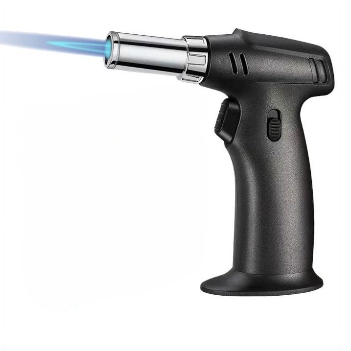 Black handheld butane torch emitting a blue flame