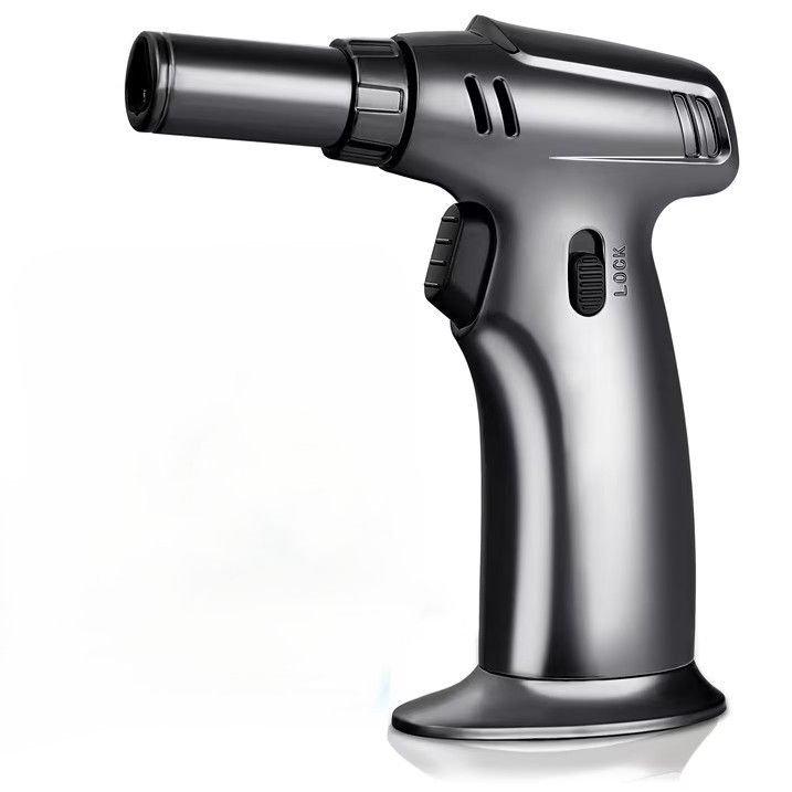 Black handheld butane torch emitting a blue flame