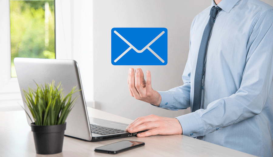 A Man Is Typing on A Laptop Computer While Holding an Envelope in His Hand.