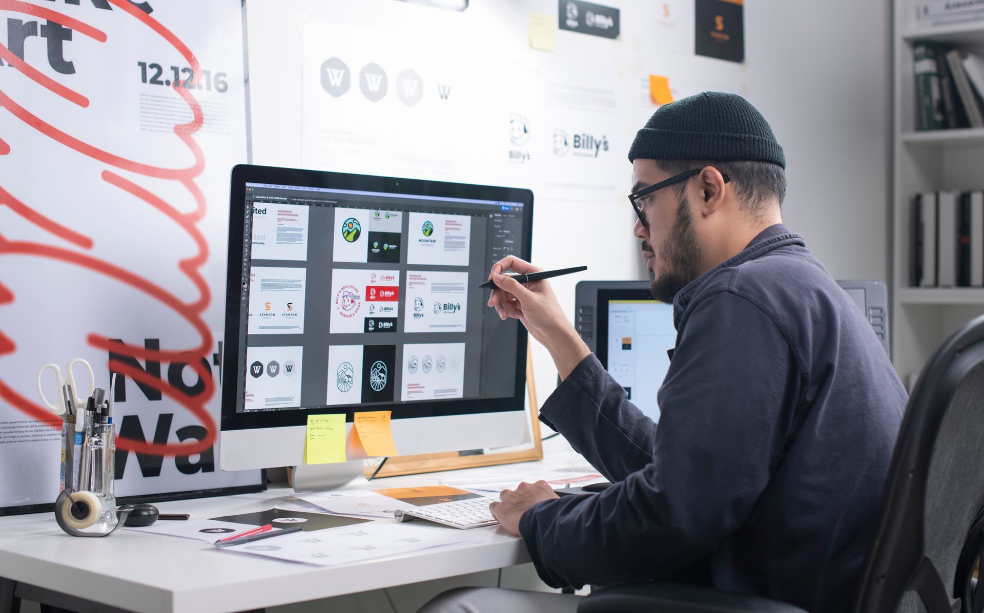 A Man Is Sitting at A Desk in Front of A Computer.