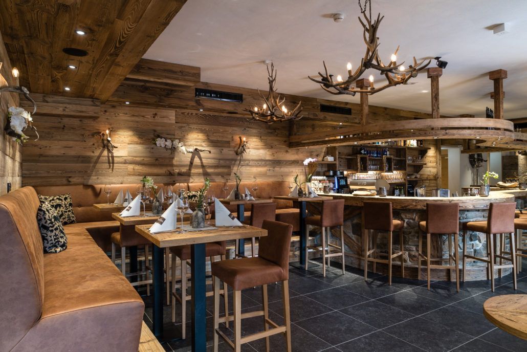 Ein Restaurant mit Tischen und Stühlen und einem Kronleuchter, der von der Decke hängt.