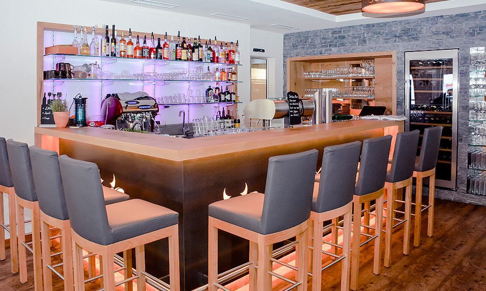 Eine lange Bar mit edlen Wandfliesen, vielen Stühlen in einem Restaurant.