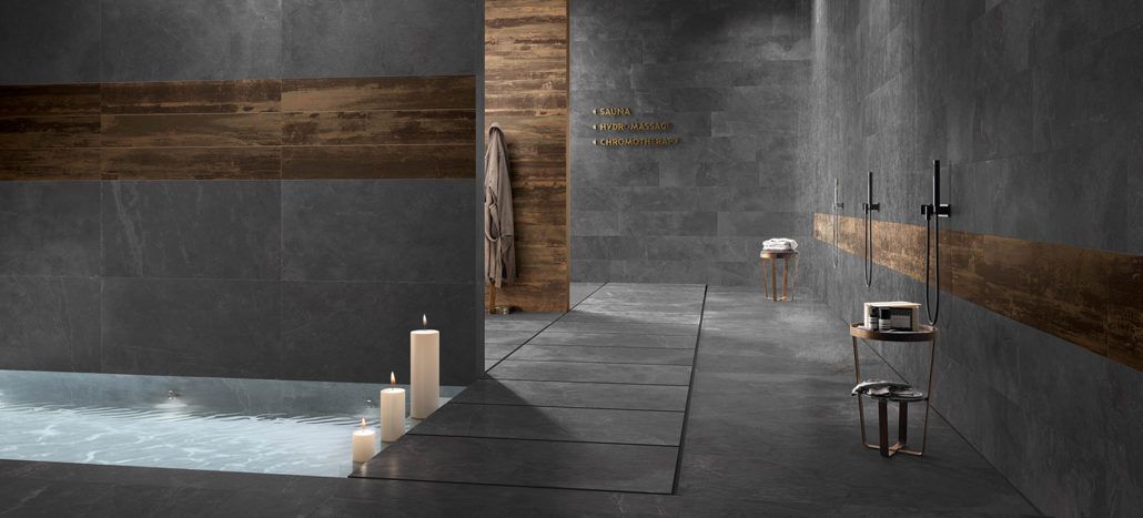 Ein Badezimmer mit Badewanne aus Fliesen, Dusche und Kerzen.