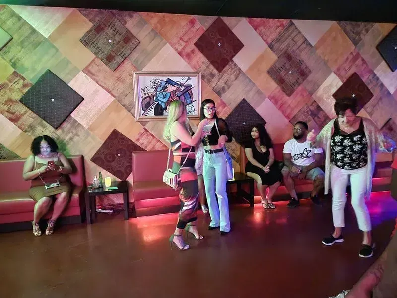 People dancing in a colorful studio with a patterned wall and wooden floor