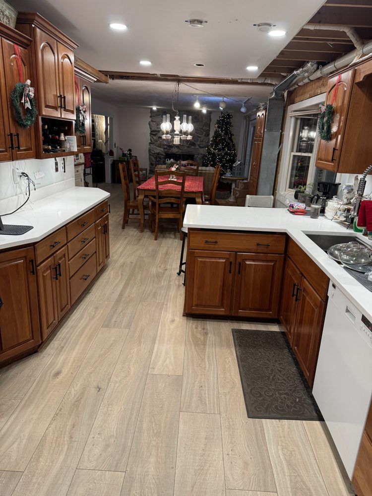 Kitchen with wood cabinets, white countertops, island, and dining table in the background.