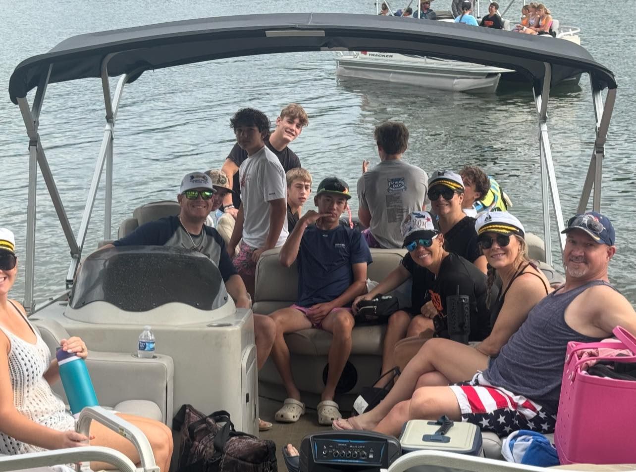 A group of people sitting on a pontoon boat on a sunny day.
