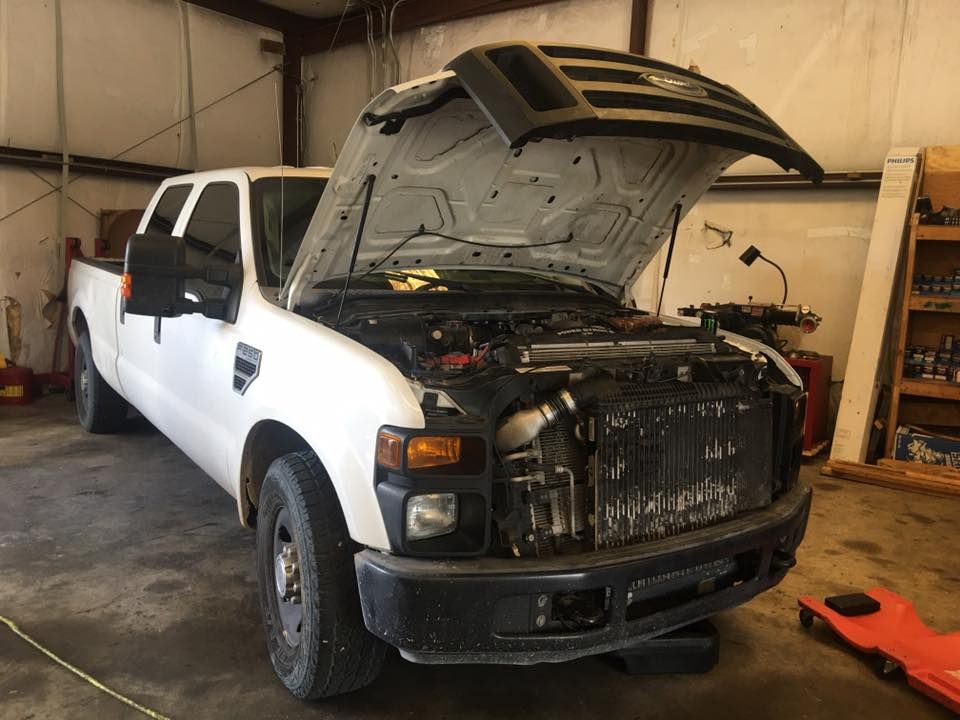 White Ford pickup truck with open hood in a garage. | William’s Auto Repair