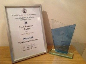 A framed certificate and a glass trophy for the Best New Business