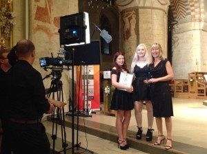A man is taking a picture of three women in a church.