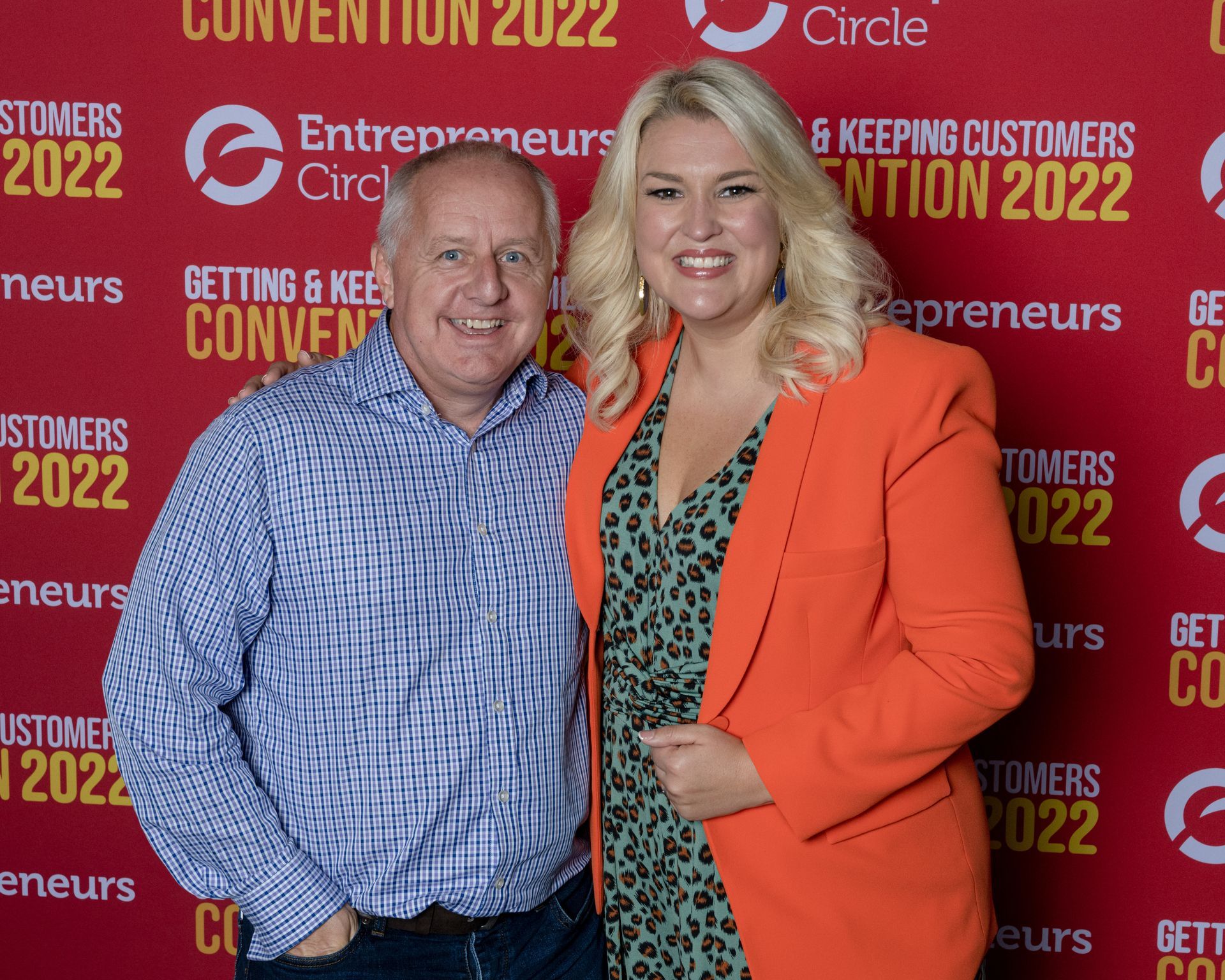 Peter Barker & Sara Davies are posing for a picture in front of a sign that says Entrepreneurs Convention