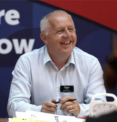 Peter Barker is smiling and wearing a name tag that says Entrepreneurs Circle Ambassador