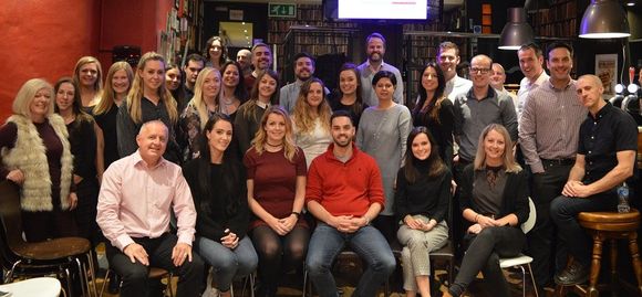 A large group of people are posing for a picture in a restaurant.