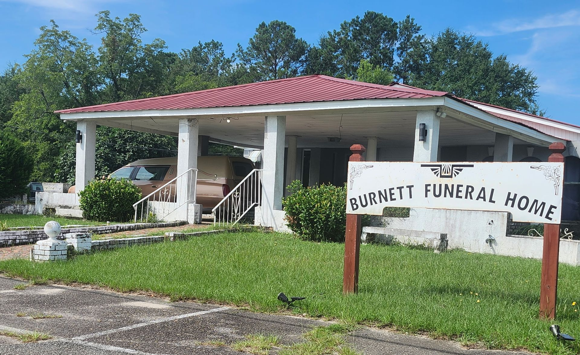 Burnett Funeral Home building with red roof and front sign on a sunny day