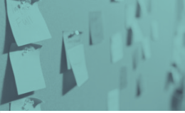 Blue-toned wall with numerous pinned, blank sticky notes, some overlapping.