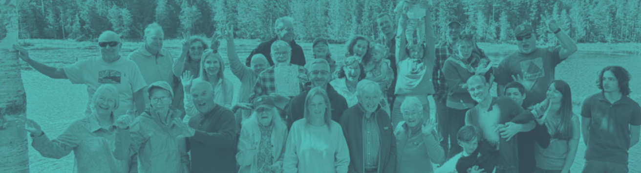 Group of people in a teal hue, outside, waving and smiling, near trees and water.