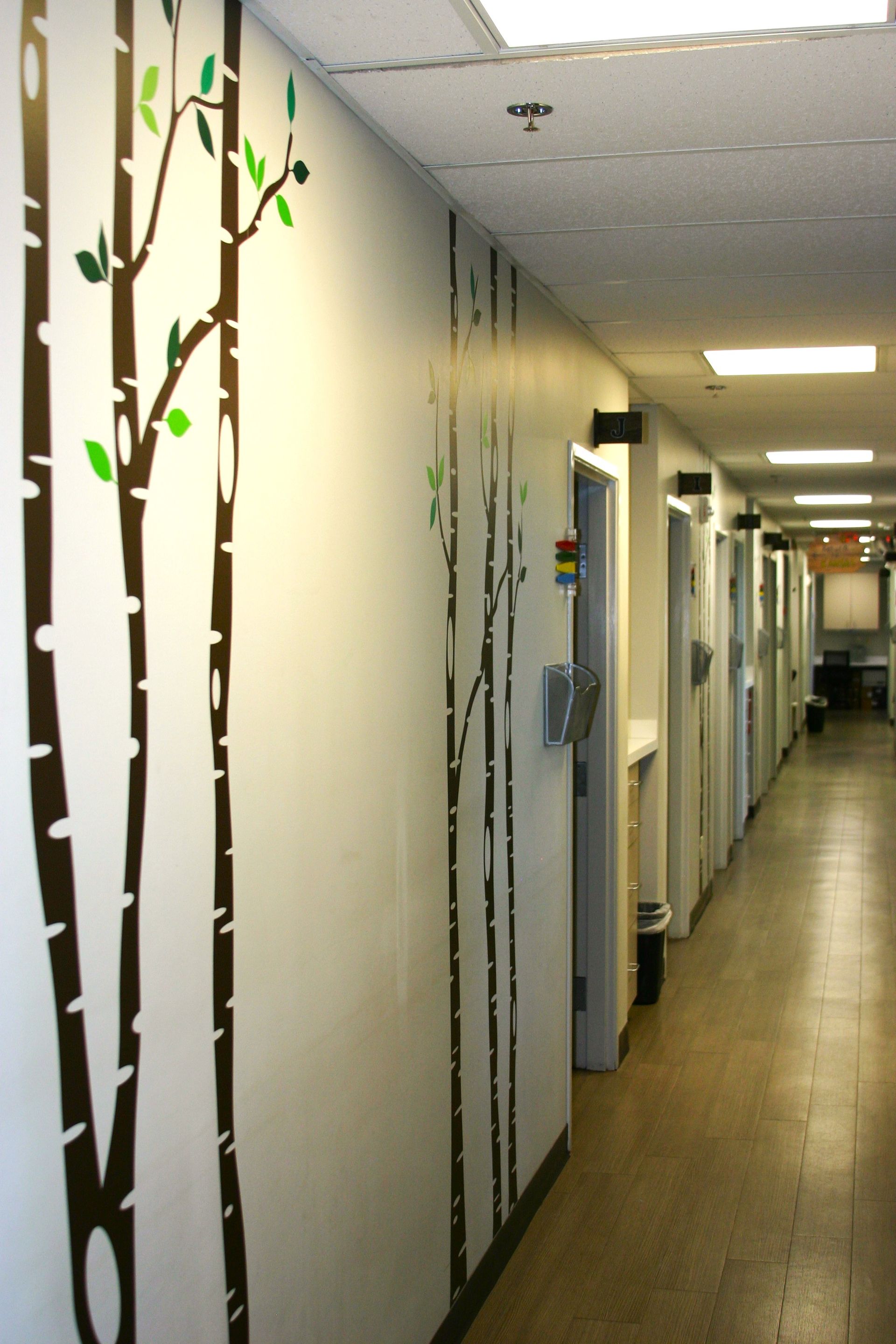 A long hallway with trees painted on the walls