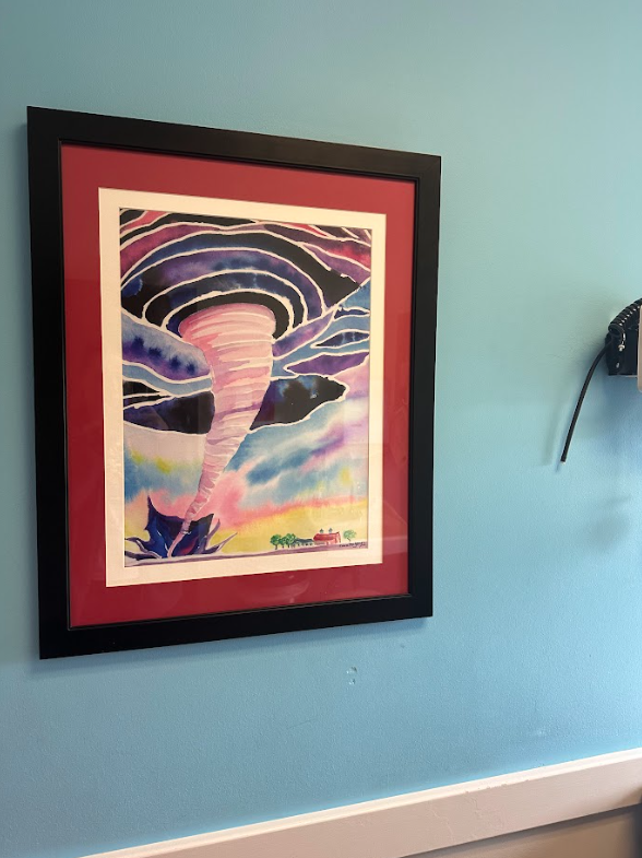 A painting of a tornado is hanging on a blue wall.