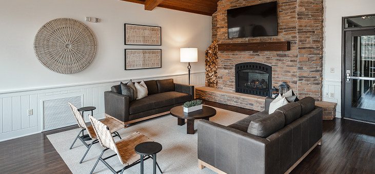Living room with couches, fireplace, chairs, and a large decorative wall piece.