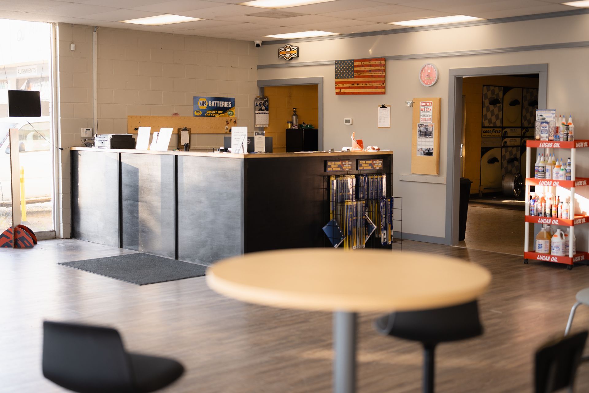 Lobby with front desk, tables, chairs, and a vending machine in a bright office waiting area