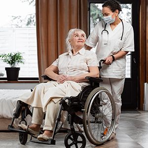 Nurse assisting elderly patient in wheelchair in a bright room